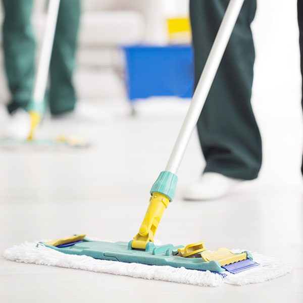 Person holding and cleaning floor mop with Dalcon Higiene product